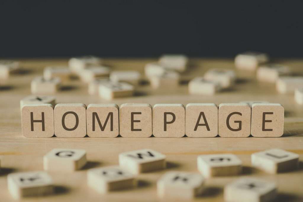 selective focus of word homepage made of cubes surrounded by blocks with letters on wooden surface
