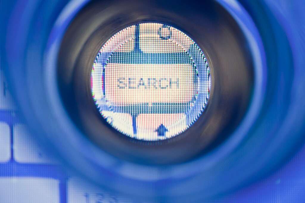 Webdesign Hannover - Nahaufnahme eines Computerbildschirms, auf dem „SEARCH“ durch eine runde Linse angezeigt wird, die an eine Lupe erinnert. Das sichtbare Pixelmuster deutet auf einen digitalen oder Internetkontext hin und lädt zur Erforschung fortgeschrittener Themen wie „Was versteht man unter semantischer Suche?“ ein. Local SEO Agentur Hannover.