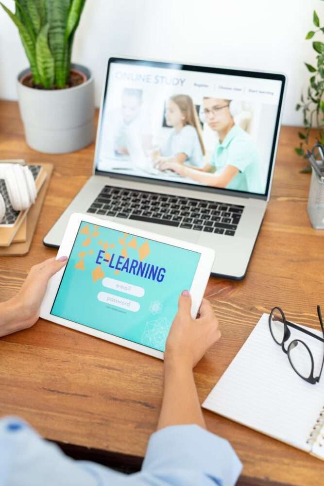 Webdesign Hannover - Eine Person sitzt an einem Schreibtisch mit einem Laptop, auf dem eine Webseite zum Thema „Online-Studium“ angezeigt wird, und wartet auf den Relaunch der Website durch ihre Agentur. Sie hält ein Tablet in der Hand, auf dem ein Anmeldebildschirm für „E-Learning“ angezeigt wird. In der Nähe vervollständigen eine Brille, ein Notizbuch, ein Stift und eine kleine Pflanze das Setup. Local SEO Agentur Hannover.